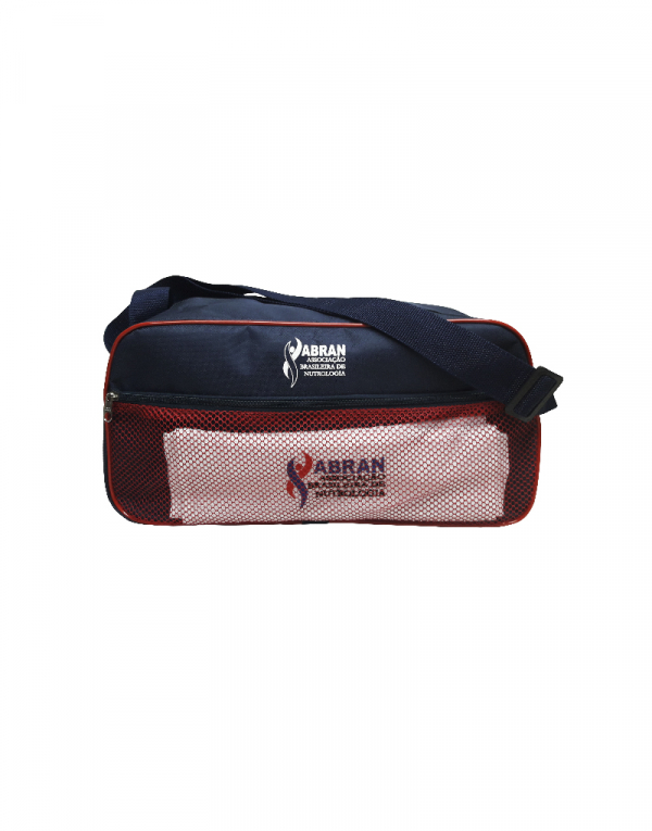 mala de viagem curta produzida em poliester 600 preto com detalhes em poliester 600 vermelho e tela frontal vermelha com toalha ilustratica dentro do bolso frontal