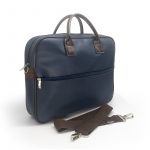 Pasta em sintetico prada azul marinho e detalhes em sintetico cedro marrom possui bolso frontal e alça transversa ideal para o trabalho imagem na diagonall